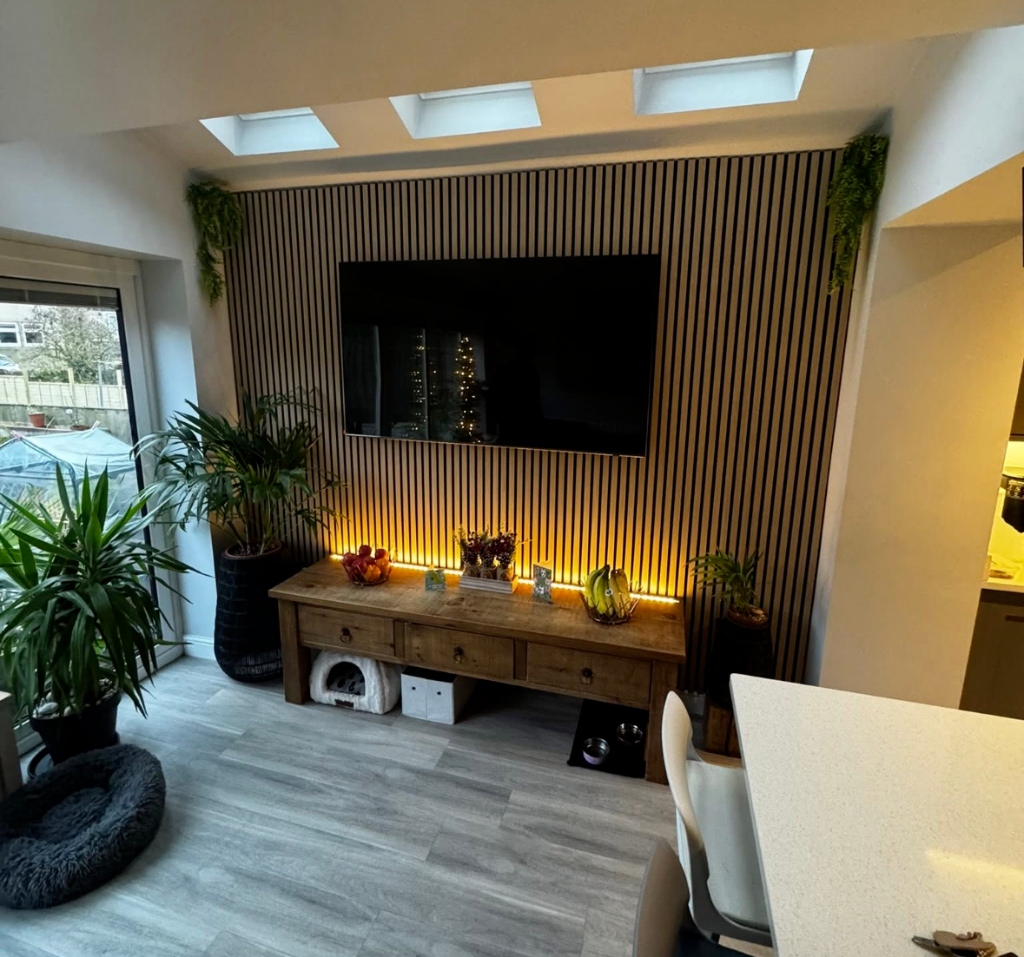 Modern media wall with wood slat panels and warm ambient lighting